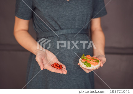 A thoughtful pregnant woman over 40 considering whether to eat fish or opt for omega 3 capsules for a nourishing and healthy pregnancy A thoughtful pregnant woman over 40 considering whether to eat fish or opt for omega 3 capsules for a nourishing and healthy pregnancy 105721041