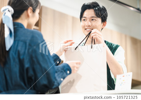 男店員在商店裡將產品交給顧客 105721325