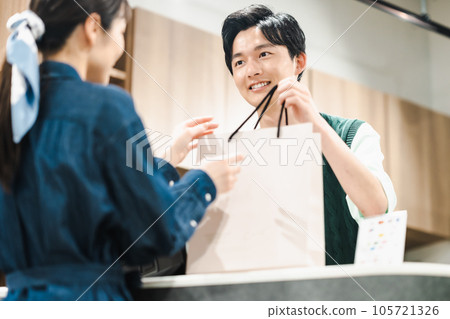 男店員在商店裡將產品交給顧客 男店員在商店裡將產品交給顧客 105721326