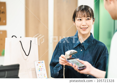 用二維碼付款的男士和掃碼的女店員 用二維碼付款的男士和掃碼的女店員 105721328