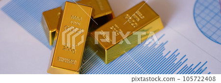 Gold bars on financial reports and charts close up. 105722408
