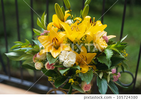 a bouquet of beautiful yellow flowers in a vase outdoors 105724380