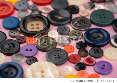 Many different buttons on a pink background Many different buttons on a pink background 105724483