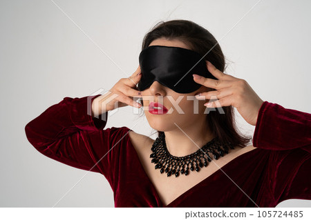 elegant luxury blind woman in evening dress with blindfold posing on white background elegant luxury blind woman in evening dress with blindfold posing on white background 105724485