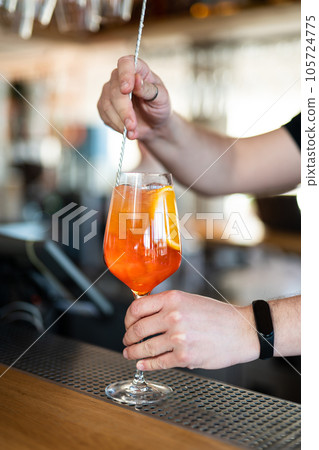the bartender prepares a beautiful alcoholic cocktail at the bar counter 105724775