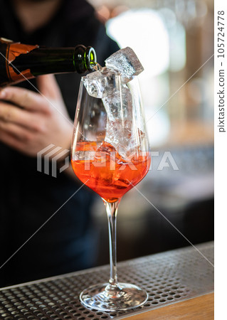 the bartender prepares a beautiful alcoholic cocktail at the bar counter 105724778