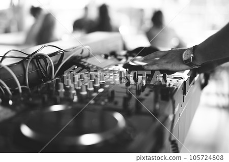 a DJ plays music on a controller at a party a DJ plays music on a controller at a party 105724808