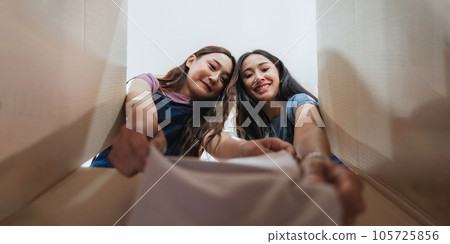 Closeup view of Two beautiful freelance business women sell online while preparing pack product box in her startup small business E-commerce shipping concept Closeup view of Two beautiful freelance business women sell online while preparing pack product box in her startup small business E-commerce shipping concept 105725856