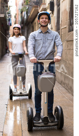 Young couple guy and girl walking on segway in streets of european city 105727162