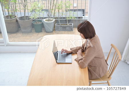 Young woman working on a laptop indoors Young woman working on a laptop indoors 105727849