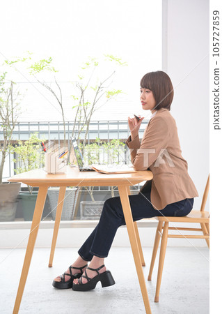 A woman doing disk work at an indoor desk A woman doing disk work at an indoor desk 105727859