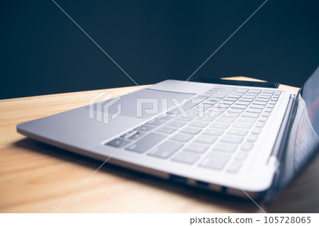 Side view laptop with blank screen, Placed on a wooden table in office and nobody. Workspace with computer, Technology, Internet, Work, Back to school, Online shopping concept. Left side copy space. 105728065