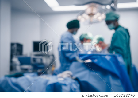 Blurred image background of medical team performing surgical operation in operating room. An operating room may be designed and equipped to provide care to patients. Blurred image background of medical team performing surgical operation in operating room. An operating room may be designed and equipped to provide care to patients. 105728770
