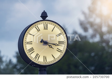 Railway station clock on the column on sky background. Railway station clock on the column on sky background. 105730700