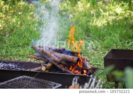 burning firewood in a barbecue on the lawn. picnic 105732221