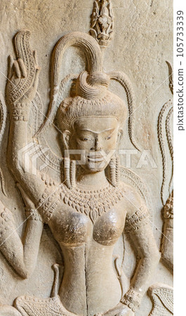 Wall carving with womans dancers apsara. Ancient ruins Angkor Wat temple - famous Cambodian landmark. Siem Reap, Cambodia. 105733339