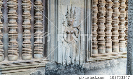 Wall carving with womans dancers apsara. Ancient ruins Angkor Wat temple - famous Cambodian landmark. Siem Reap, Cambodia. 105733347