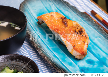 A fillet of alfonsino. A Japanese breakfast scene with miso soup, pickles and grilled fish. A fillet of alfonsino. A Japanese breakfast scene with miso soup, pickles and grilled fish. 105734120