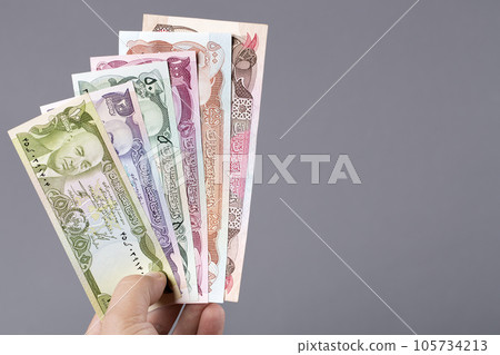 Afghan money in the hand on a gray background Afghan money in the hand on a gray background 105734213