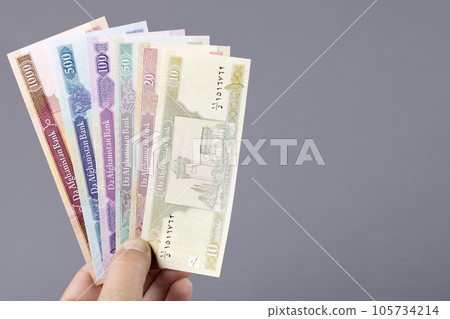 Old Afghan money in the hand on a gray background Old Afghan money in the hand on a gray background 105734214