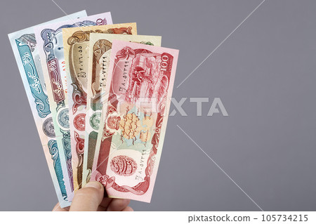 Afghan money in the hand on a gray background Afghan money in the hand on a gray background 105734215