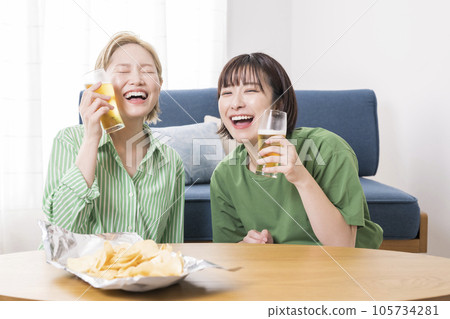 woman drinking beer in living room 105734281