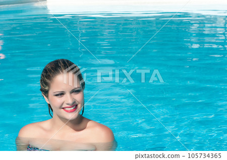 attractive young woman bathing in a pool 105734365