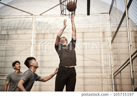 young asian adult men playing basketball on outdoor court young asian adult men playing basketball on outdoor court 105735197