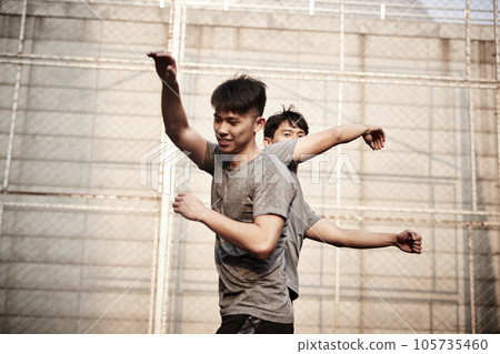 two young asian athletes bumping body celebrating success two young asian athletes bumping body celebrating success 105735460