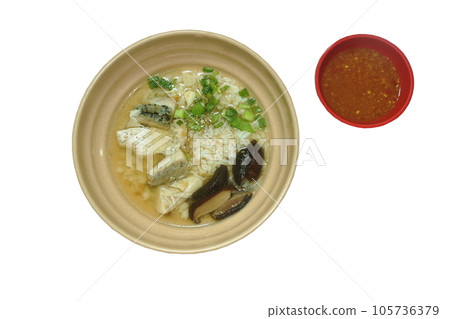 boiled rice with slice bass fish topping chop spring onion and fried garlic in clear soup on bowl dipping spicy chili sauce  105736379
