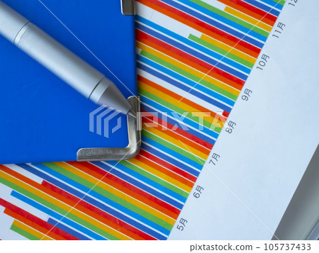 Graphs and blue binders on the table Graphs and blue binders on the table 105737433