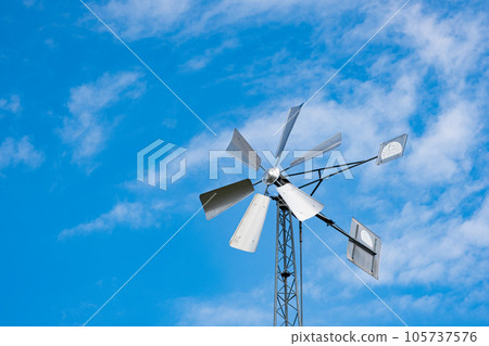 Wind generator with solar panels on the background of the sky, space for text 105737576