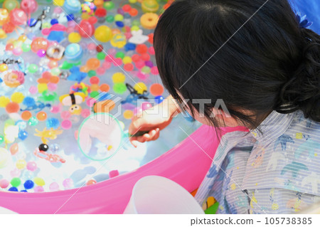 一個穿著浴衣的女孩正在舀一個超級球 一個穿著浴衣的女孩正在舀一個超級球 105738385