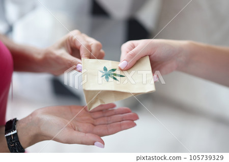 Handing over paper bag with marijuana sign. Handing over paper bag with marijuana sign. 105739329