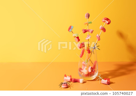 Marmalade on sticks in a glass cup against an orange background Marmalade on sticks in a glass cup against an orange background 105740027