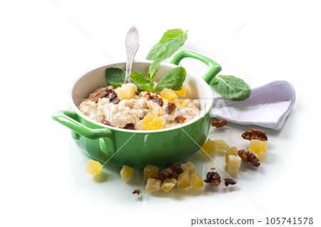 cooked boiled sweet oatmeal with nuts and candied fruits in a bowl cooked boiled sweet oatmeal with nuts and candied fruits in a bowl 105741578