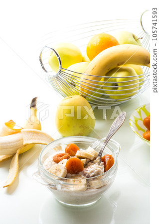 cooked boiled sweet oatmeal with with dried apricots and bananas in a bowl 105741593