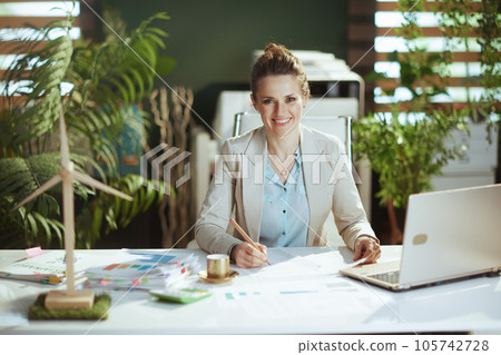 smiling business owner woman in green office smiling business owner woman in green office 105742728