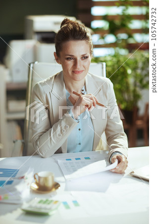pensive female employee in light business suit in green office 105742732