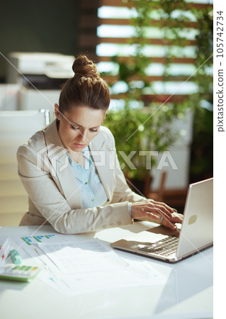 pensive woman worker in light business suit in green office pensive woman worker in light business suit in green office 105742734
