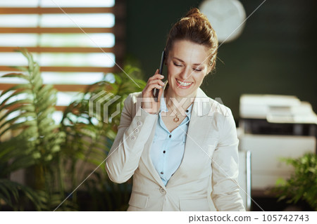 smiling business owner woman in green office talking on phone 105742743