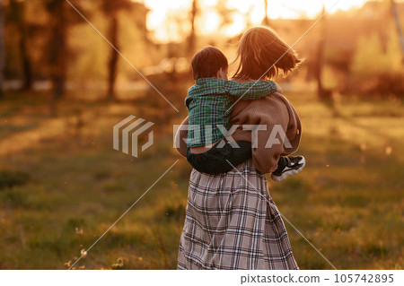 Sister carries brother in her arms 105742895