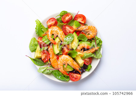 Healthy salad with grilled shrimps, avocado, cherry tomatoes and green leaves on white plate isolated on white background top view. Clean eating, nutrition and dieting concept Healthy salad with grilled shrimps, avocado, cherry tomatoes and green leaves on white plate isolated on white background top view. Clean eating, nutrition and dieting concept 105742966
