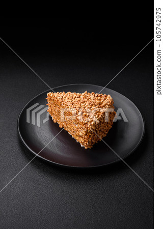 Delicious sweet puff waffle cake with cream and nuts cut into pieces Delicious sweet puff waffle cake with cream and nuts cut into pieces 105742975