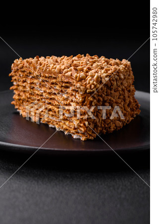 Delicious sweet puff waffle cake with cream and nuts cut into pieces Delicious sweet puff waffle cake with cream and nuts cut into pieces 105742980