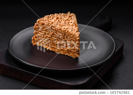 Delicious sweet puff waffle cake with cream and nuts cut into pieces Delicious sweet puff waffle cake with cream and nuts cut into pieces 105742981