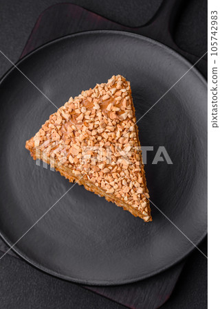 Delicious sweet puff waffle cake with cream and nuts cut into pieces Delicious sweet puff waffle cake with cream and nuts cut into pieces 105742983