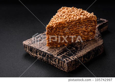 Delicious sweet puff waffle cake with cream and nuts cut into pieces Delicious sweet puff waffle cake with cream and nuts cut into pieces 105742997