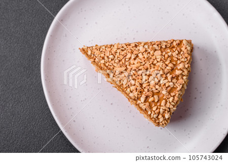 Delicious sweet puff waffle cake with cream and nuts cut into pieces 105743024