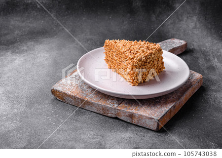 Delicious sweet puff waffle cake with cream and nuts cut into pieces 105743038